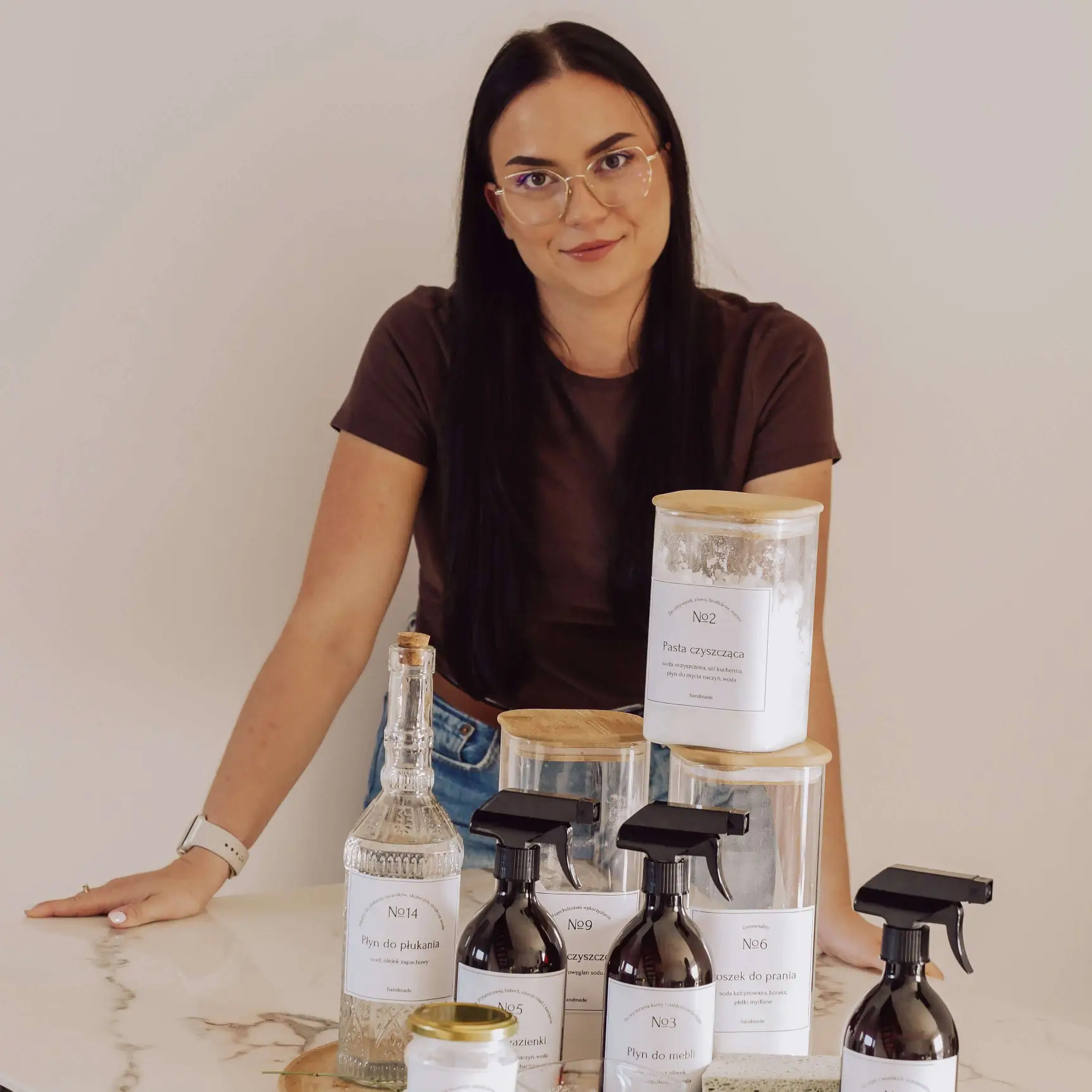 Kasia opierająca się o stół z eko produktami